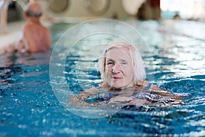 Senior active lady swims in the pool