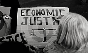 Senior activist preparing protest banners against financial crisis - Economic justice activism concept