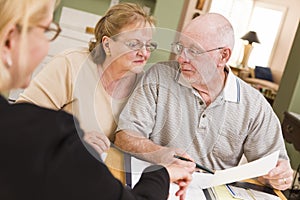 Senior Adult Couple Going Over Papers in Their Home with Agent