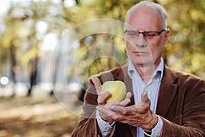 Senior adult holding green apple