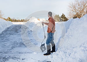 Senior adult man happy after digging out drive in snow