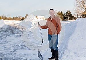 Senior adult man happy after digging out drive in snow