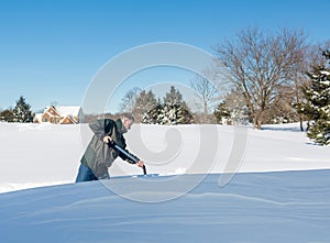 Senior adult man trying to dig out drive in snow