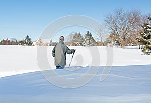 Senior adult man trying to dig out drive in snow