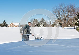 Senior adult man trying to dig out drive in snow