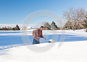 Senior adult man trying to dig out drive in snow