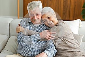 Senior adult mature couple hugging at home. Mid age old husband and wife embracing with tenderness love enjoying sweet