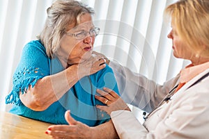 Senior Adult Woman Talking with Female Doctor About Sore Shoulder