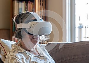 Senior adult woman watching an app on a modern VR headset