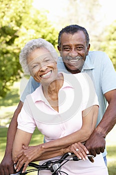 Senior African American Couple Cycling In Park