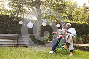 Senior African American couple sitting in their back garden