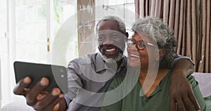 A senior african american couple spending time together at home taking a picture social distancing i