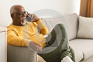 Senior African American Male Talking On Phone At Home, Side-View