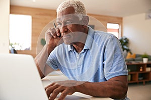 Senior African American Man Using Laptop To Check Finances At Home