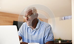 Senior African American Man Using Laptop To Check Finances At Home