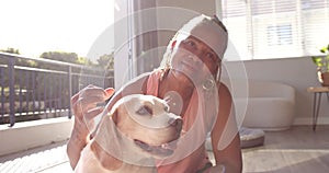 A senior African American woman enjoys time with her dog at home