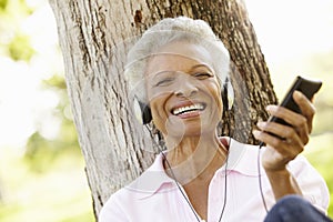 Senior African American Woman In Listening To MP3 Player