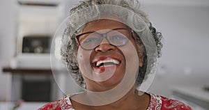 A senior african american woman smiling at the camera. social distancing in quarantine.