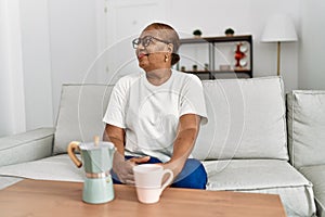 Senior african american woman smiling confident drinking coffee at home