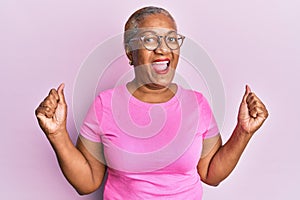Senior african american woman wearing casual clothes and glasses screaming proud, celebrating victory and success very excited