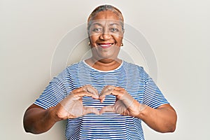 Senior african american woman wearing casual clothes smiling in love doing heart symbol shape with hands