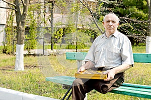 Senior amputee sitting on a park bench photo