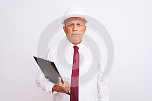 Senior architect man wearing security helmet holding clipboard over isolated white background with a confident expression on smart