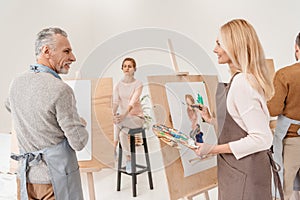 senior artists painting and looking at each other photo