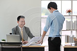 Senior Asain businessman boss satisfied and happy with young employee paperwork