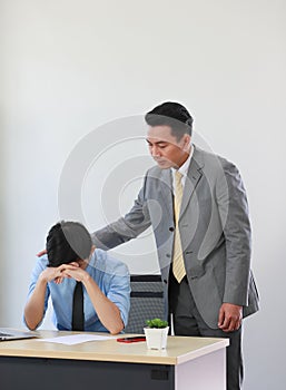 Senior Asain businessman soothing young employee who feeling stressed and upset from his work