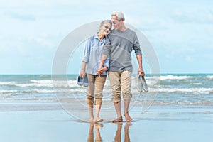 Senior asia Couple Running Along Winter Beach