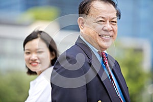 Senior Asian businessman and young female Asian executive smiling portrait