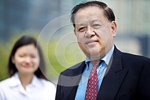 Senior Asian businessman and young female Asian executive smiling portrait