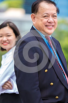 Senior Asian businessman and young female Asian executive smiling portrait