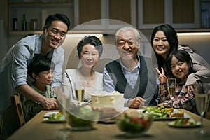 Senior asian couple celebrating wedding annversary with three generational family