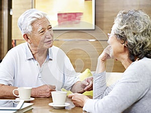 Senior asian couple chatting at home