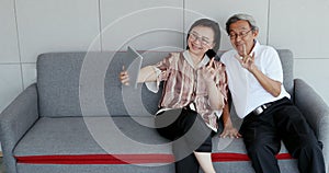 Senior Asian couple selfie their photo by tablet.