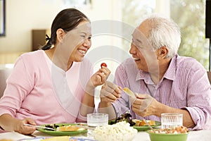 Senior asian couple sharing meal at home