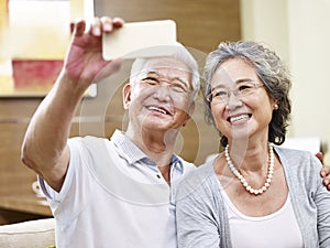 Senior asian couple taking a selfie