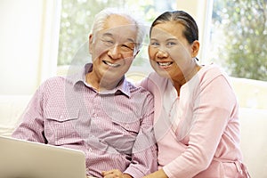 Senior Asian couple using laptop