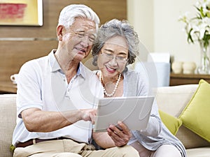 Senior asian couple using a tablet computer together