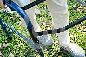 Senior asian female patient trying to walk use walking aid during rehabilitation, elderly woman walking alone with walker for