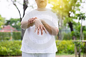 Senior asian female suffering with parkinson`s disease symptoms