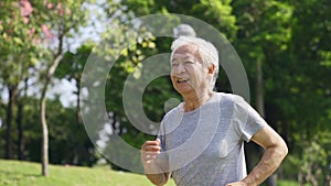 Senior asian man exercising jogging outdoors in park