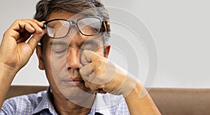 Senior asian man has eyestrain and fatigue photo
