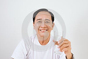 Senior asian man holding a glass of pure water