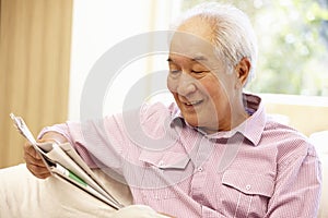 Senior Asian man reading newspaper