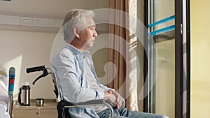 Senior asian man sitting alone in wheelchair