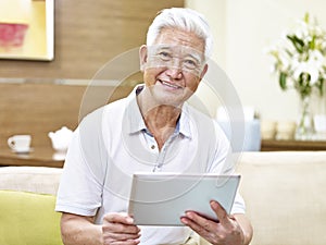 Senior asian man using tablet computer