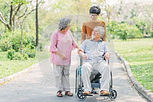 Senior Asian man in wheelchair with his wife and son